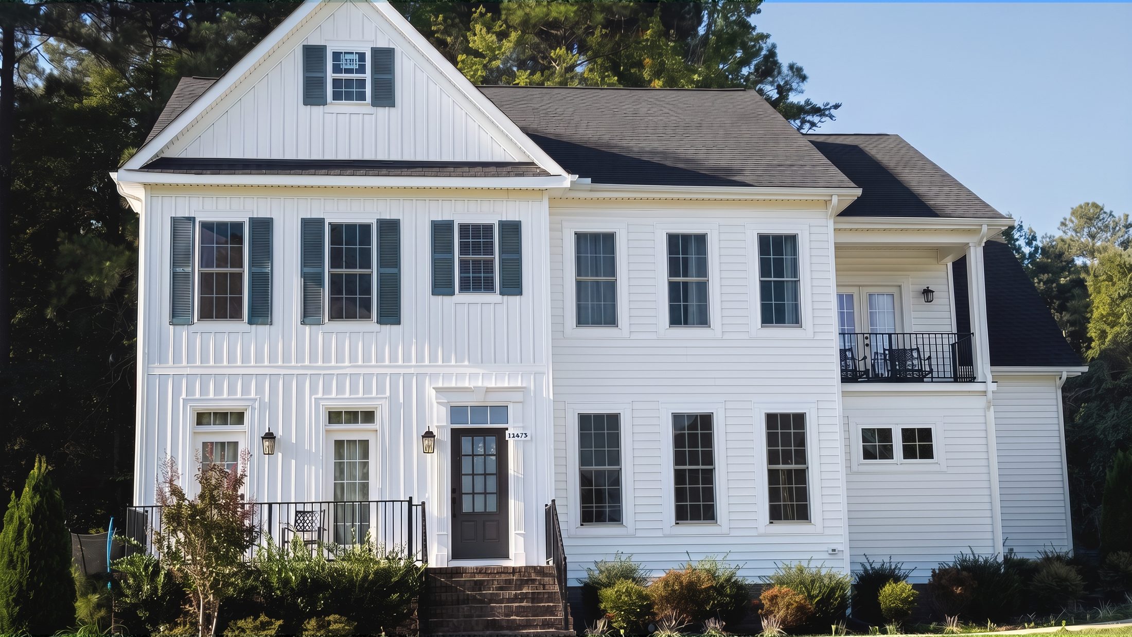The River Birch — a white colonial with black shutters and a balcony over the entry